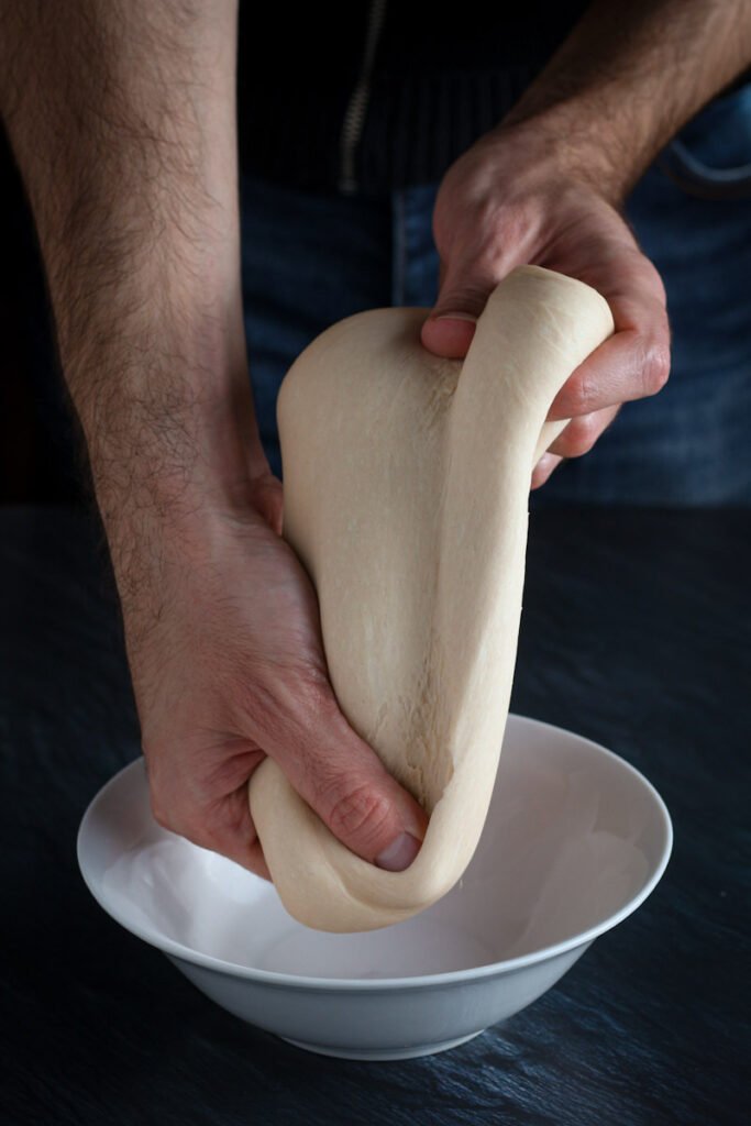 Hands stretching pizza dough
