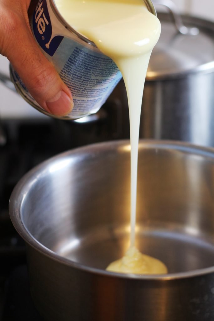 Pouring Condensed Milk into a saucepan.