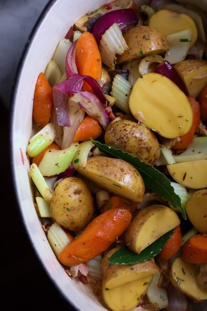 Vegetables for French Pot Roast Chicken in an enamel Dutch oven.