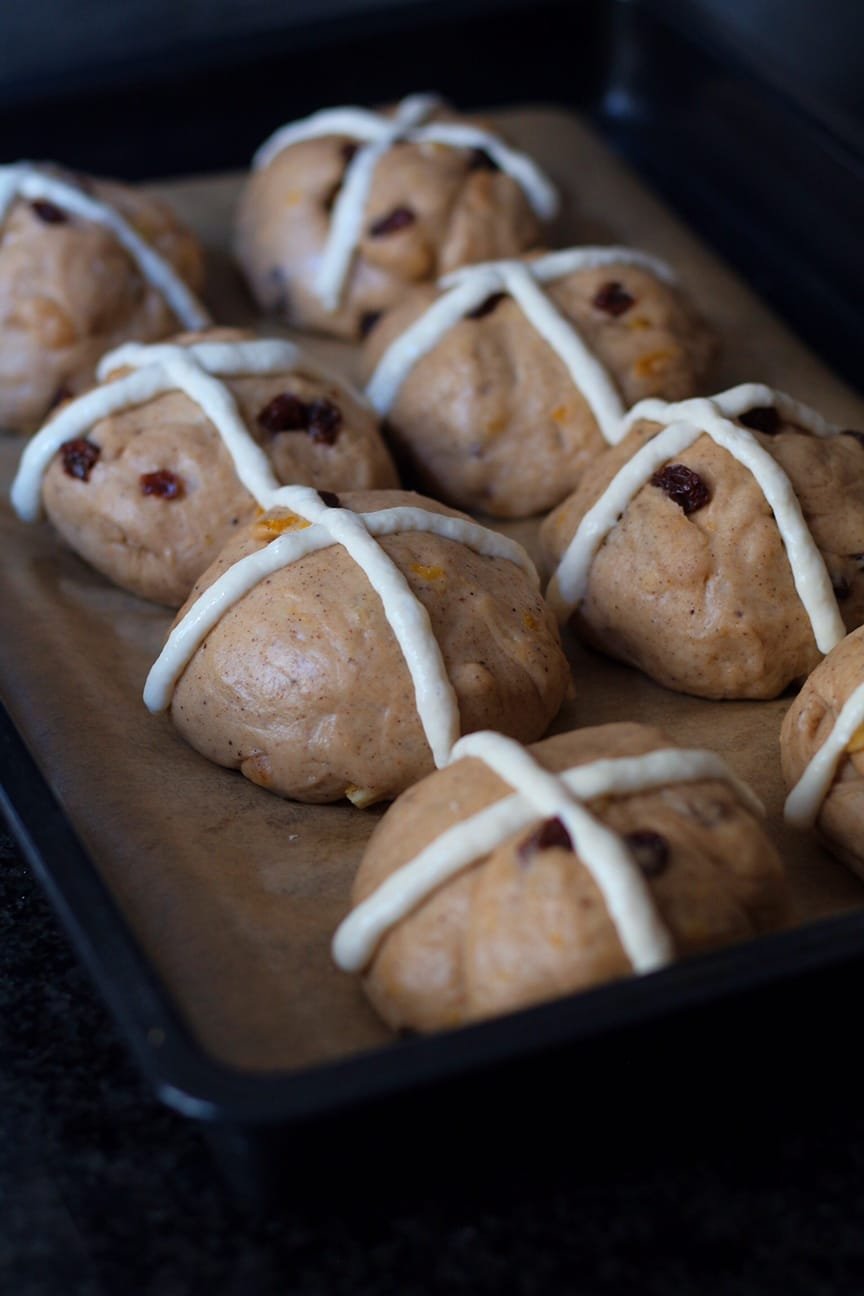 Fruity Hot Cross Buns risen and decorated with white crosses.