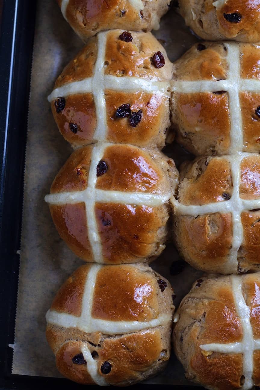 A close up of Fruity Hot Cross Buns on a baking tray seen from above.