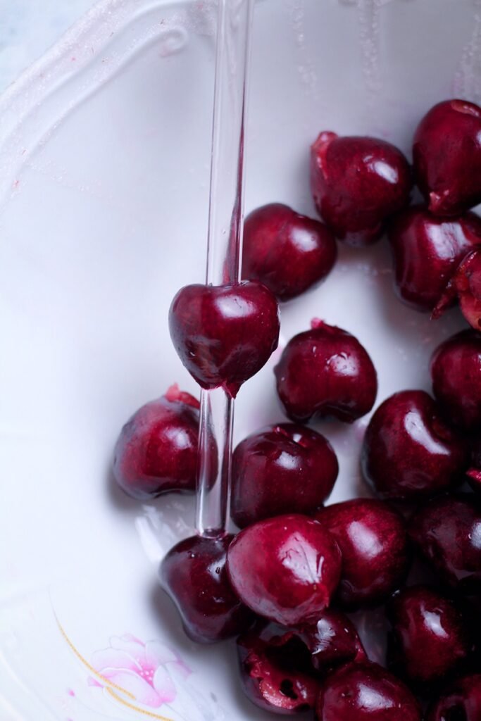 Cherries being de-stoned with a glass straw