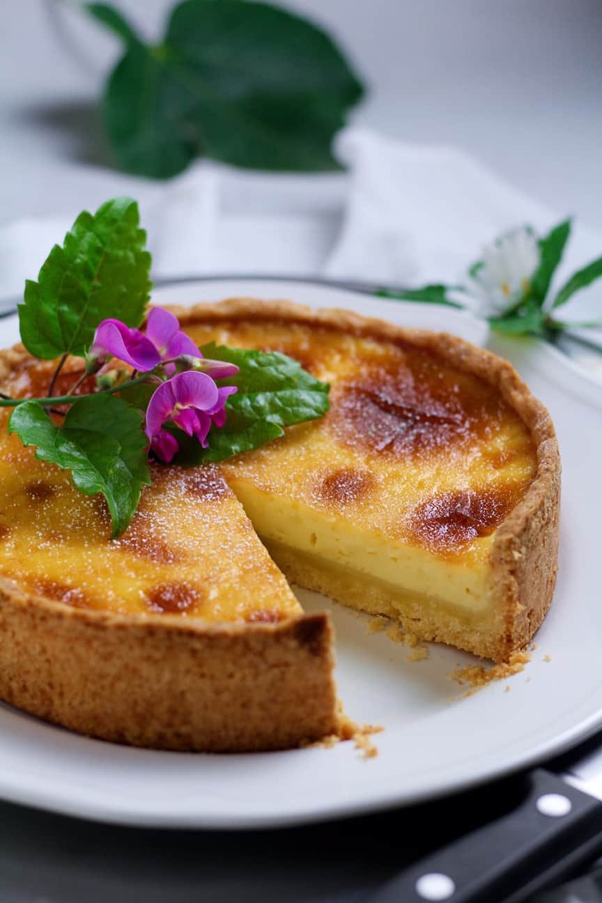 French Vanilla Custard Tart with floral decoration on a white plate
