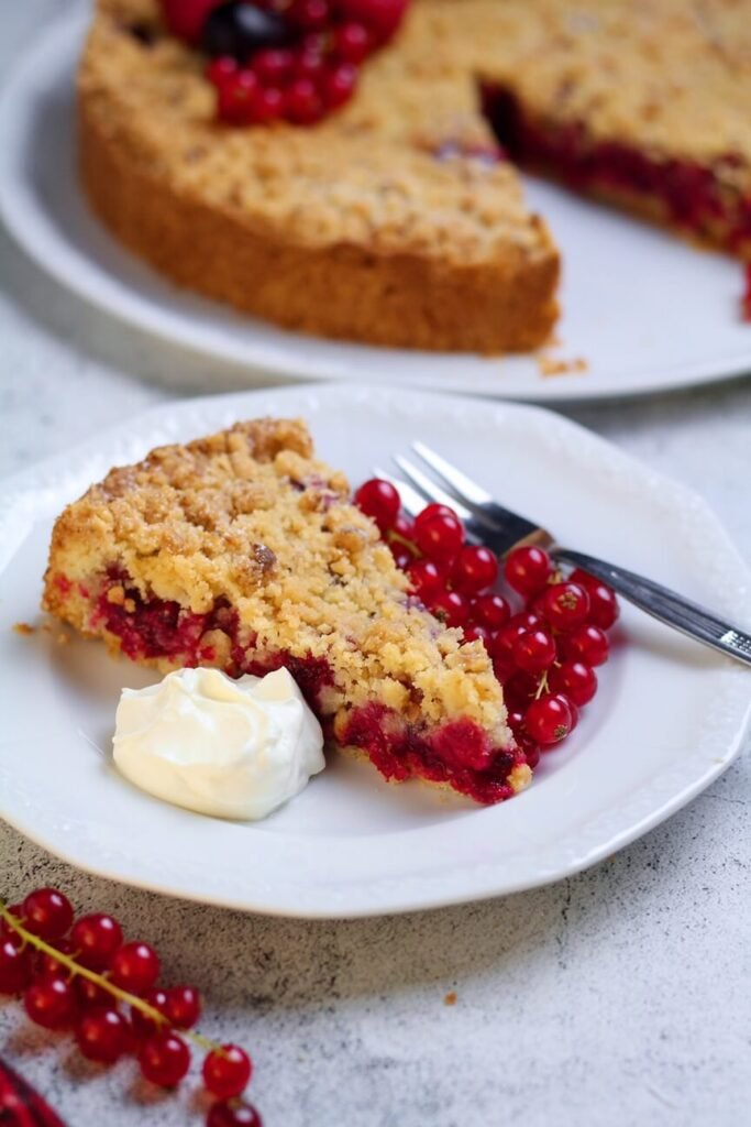 A slice of Red Currant Crumble Cake with fresh cream