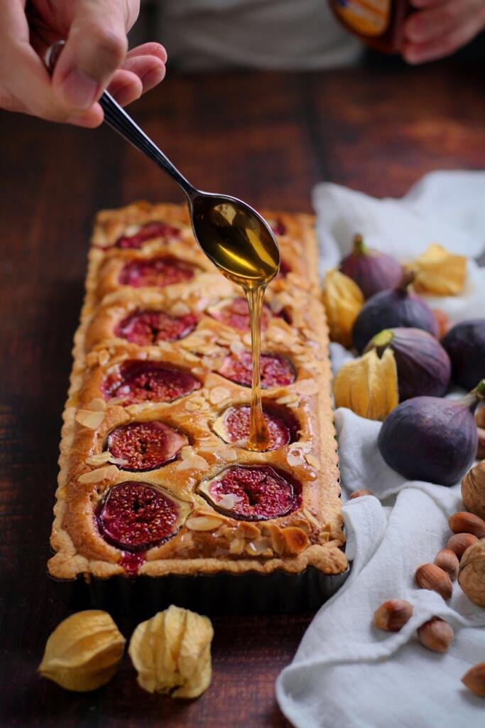 Fig and Honey Tart with honey being drizzled from a spoon.