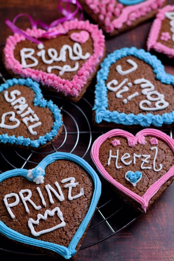 Gingerbread Hearts Lebkuchenherzen decorated with Bavarian and German greetings on a wire rack.
