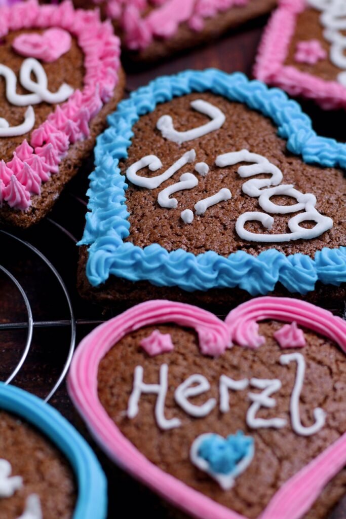 Gingerbread Hearts Lebkuchenherzen decorated with Bavarian and German greetings on a wire rack.