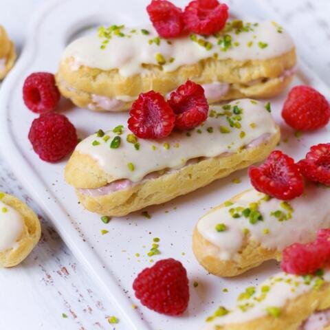 Sweet, light and dangerously addictive, Raspberry White Chocolate Eclairs with fresh raspberries, pastry cream and white chocolate are the perfect bake for your next party or afternoon tea.