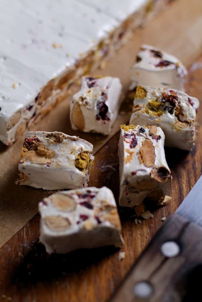 Homemade Almond and cranberry nougat sliced on a board.