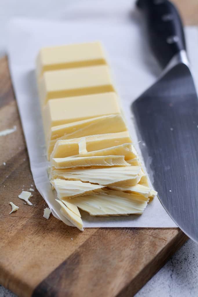 A slice block of white chocolate with a knife.