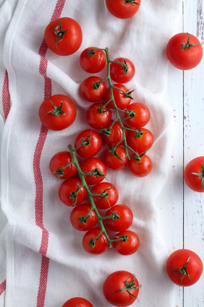 Cherry tomatoes on the vine on a kitchen cloth.