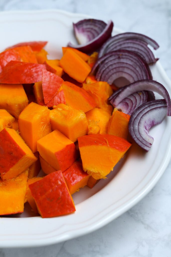 Diced pumpkin and red onion in a bowl
