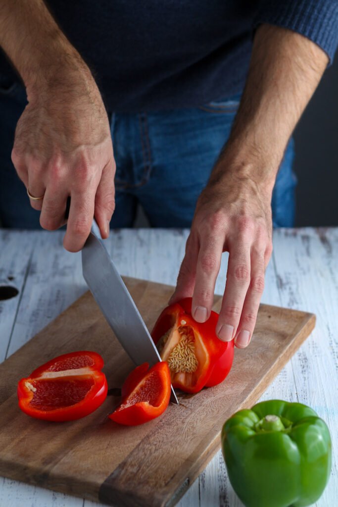 Cutting peppers on a wooden board.