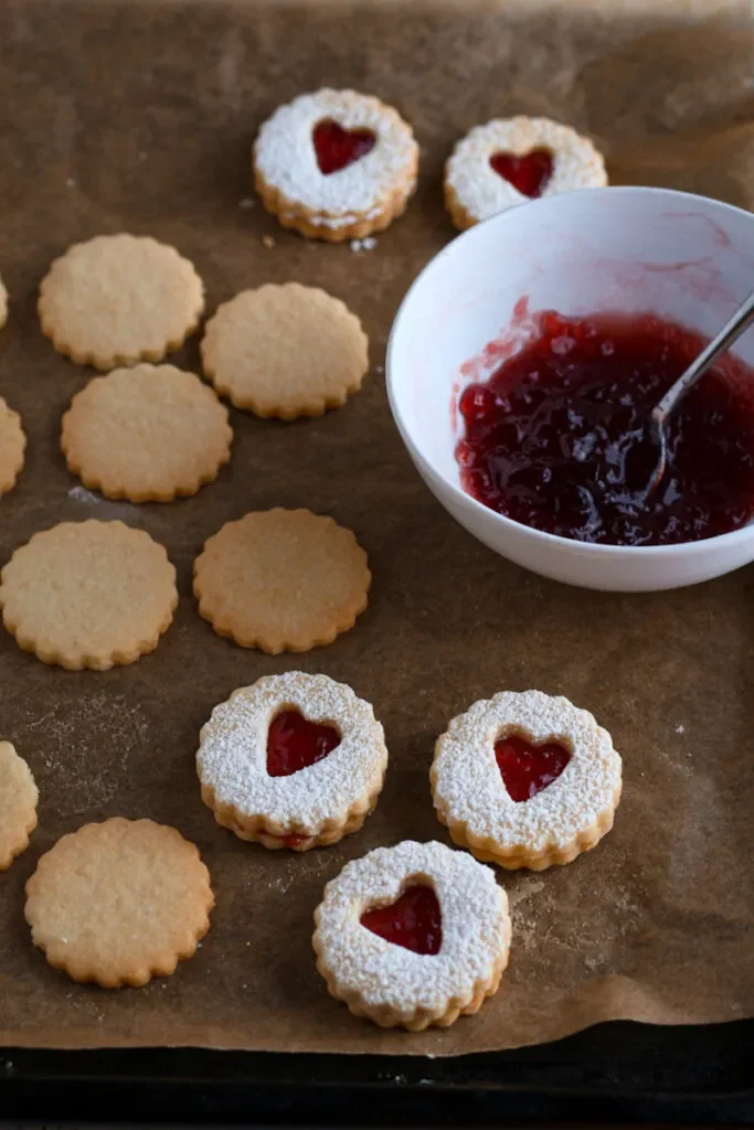 Spitzbuben cookies being assembled with redcurrant jelly