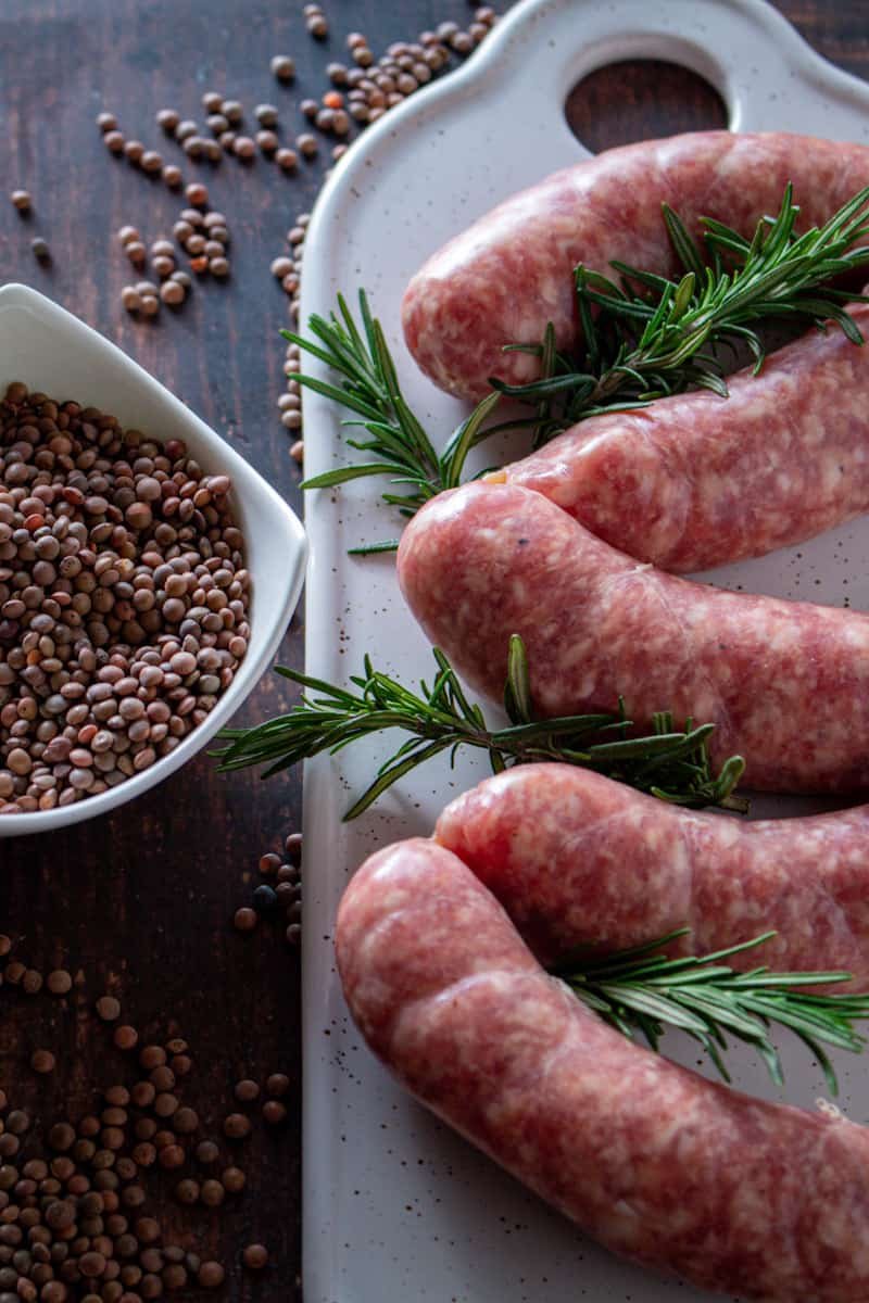 Good quality Italian sausages with a bowl of dried lentils.