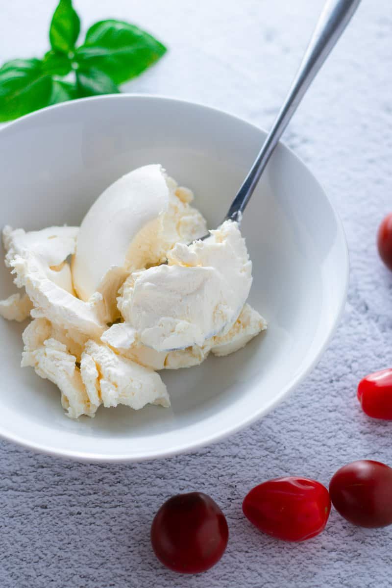 Cream Cheese in a bowl with basil and cherry tomatoes