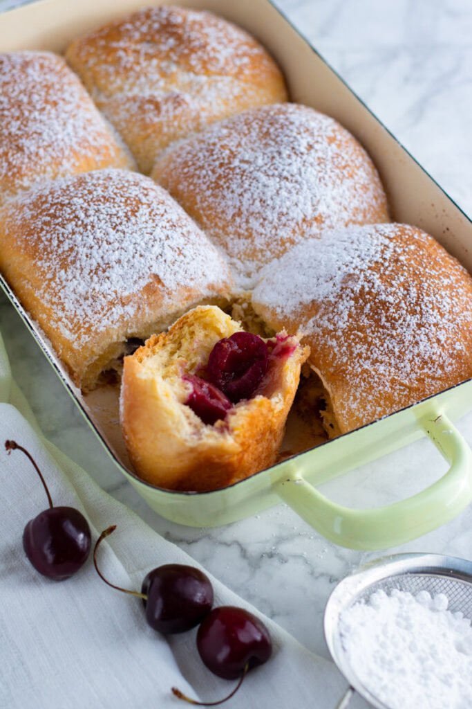 Buchteln German Sweet Dumplings filled with fresh cherries and served with vanilla sauce