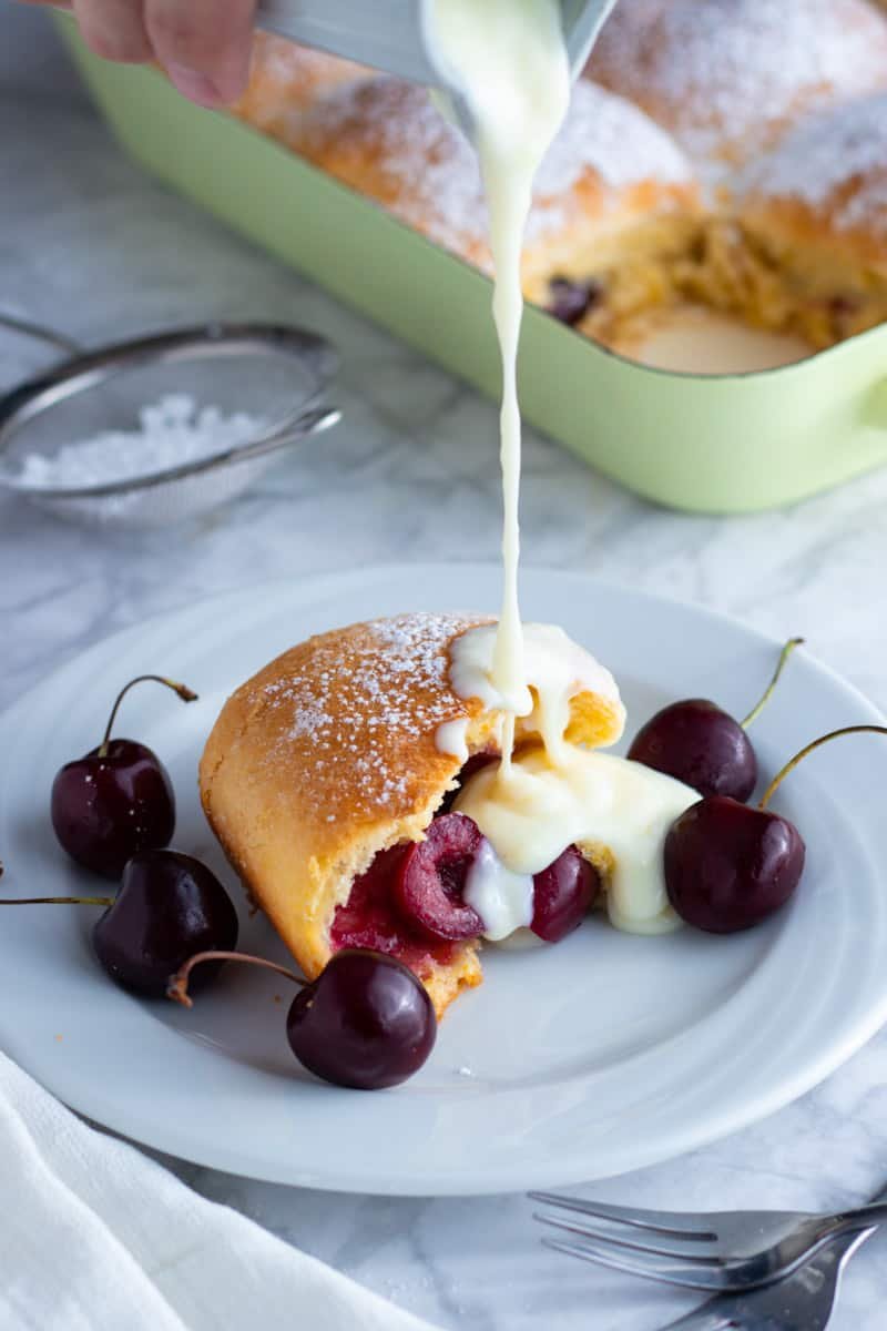 Buchteln German Sweet Dumplings filled with fresh cherries and served with vanilla sauce