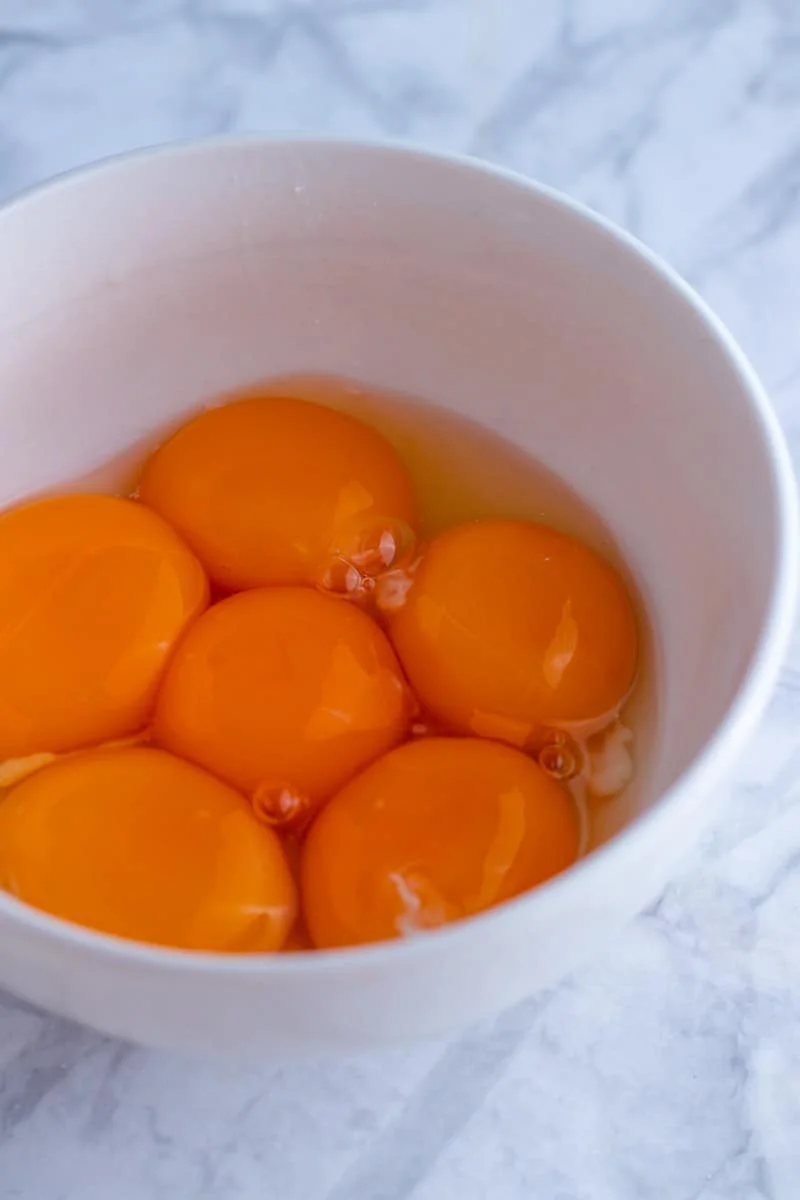 A picture of 6 egg yolks in a small bowl