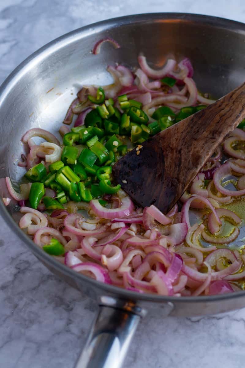 Onions and green peppers in a frying pan