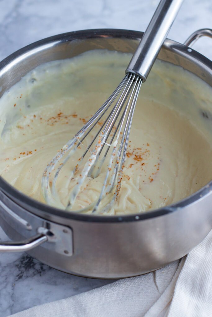 Bechamel Sauce in a pan with fresh nutmeg