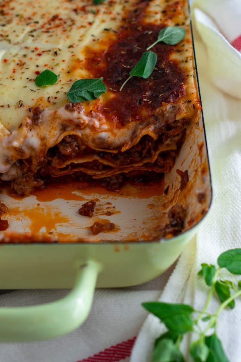 A picture of a classic Italian Lasagne al forno served with fresh green salad and a glass of white wine