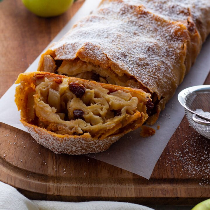 German Apple Strudel on a chopping board with fresh apples