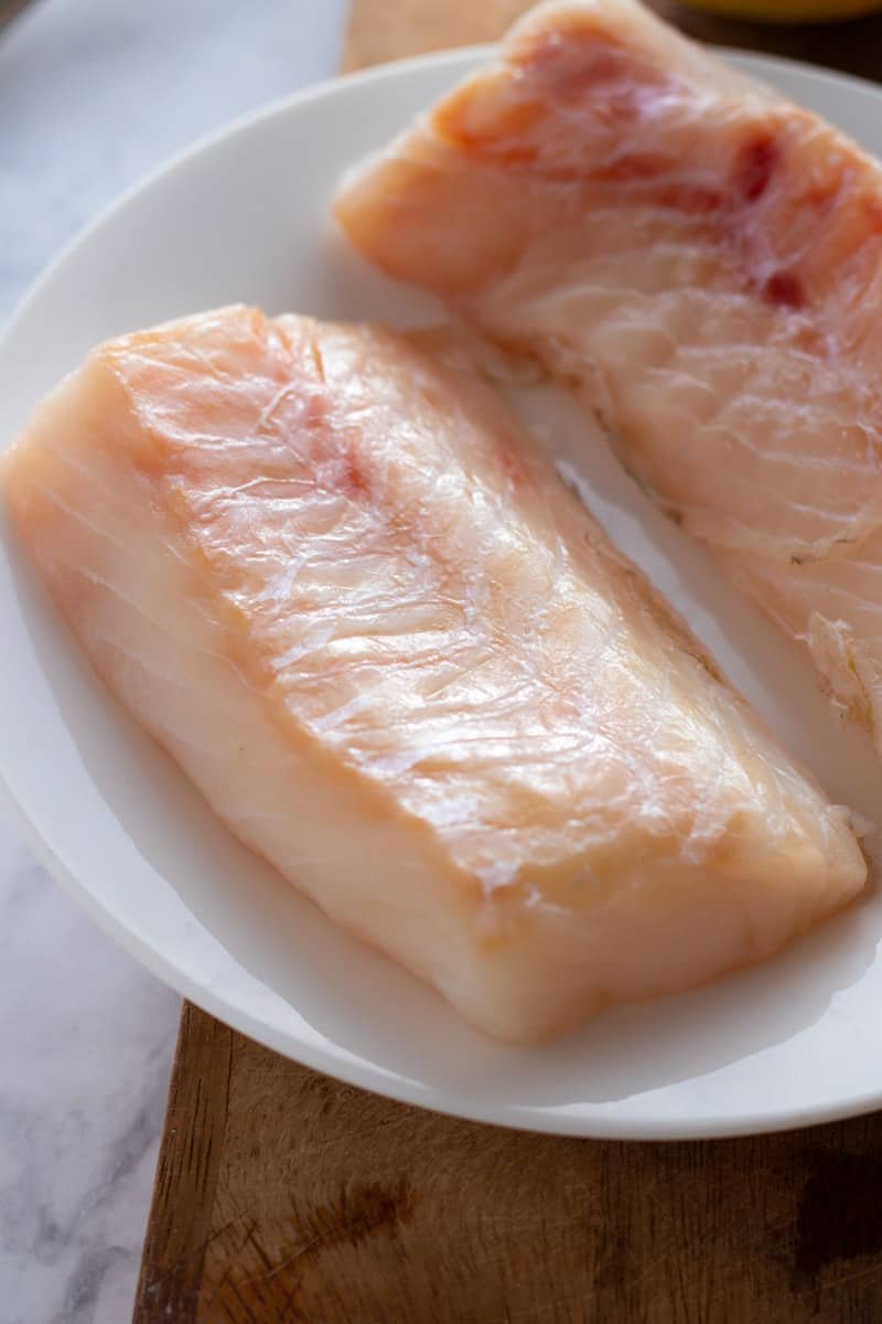 Fresh cod fillets on a plate.