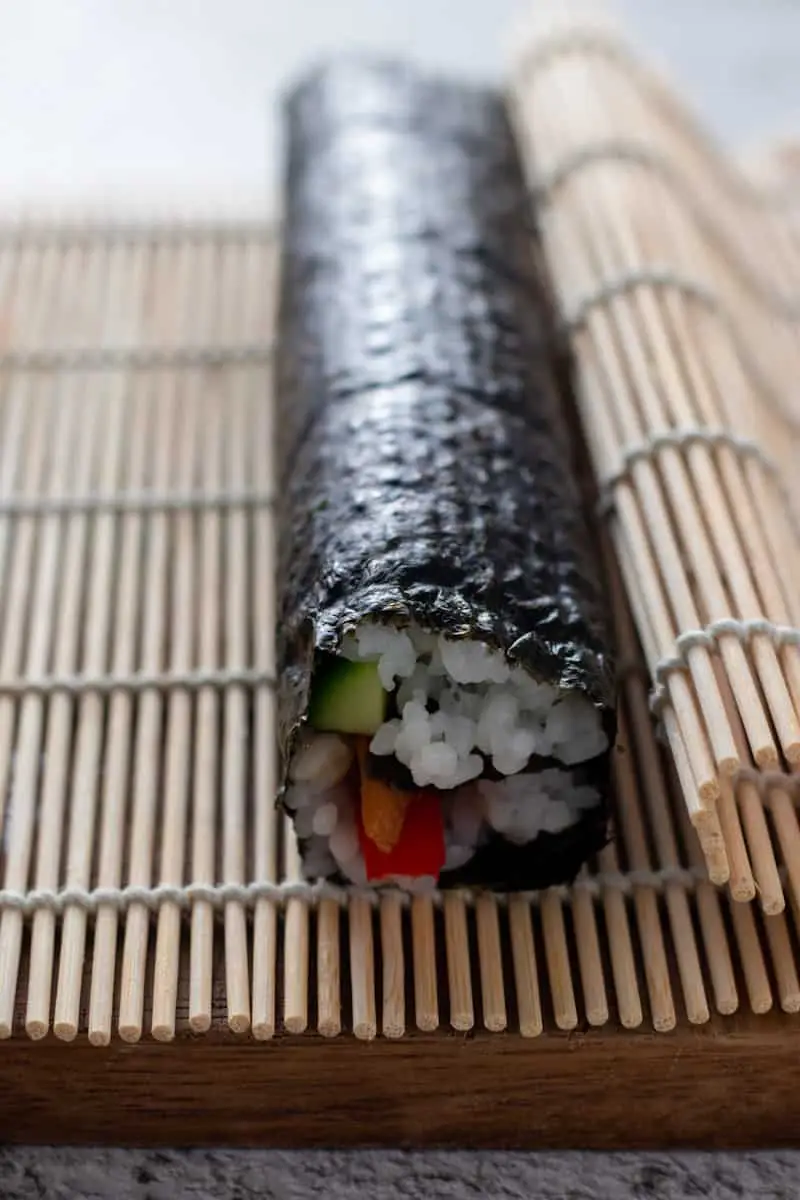 Rolled sushi roll and bamboo mat.