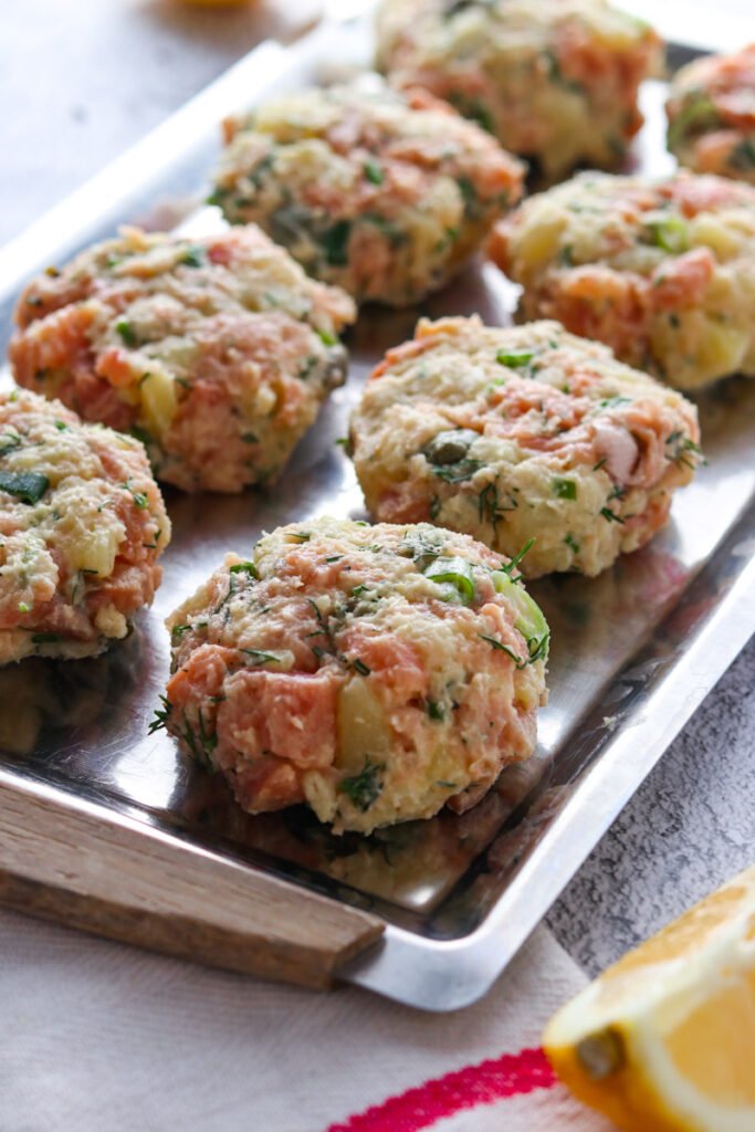 Rolled salmon cake patties on a tray.