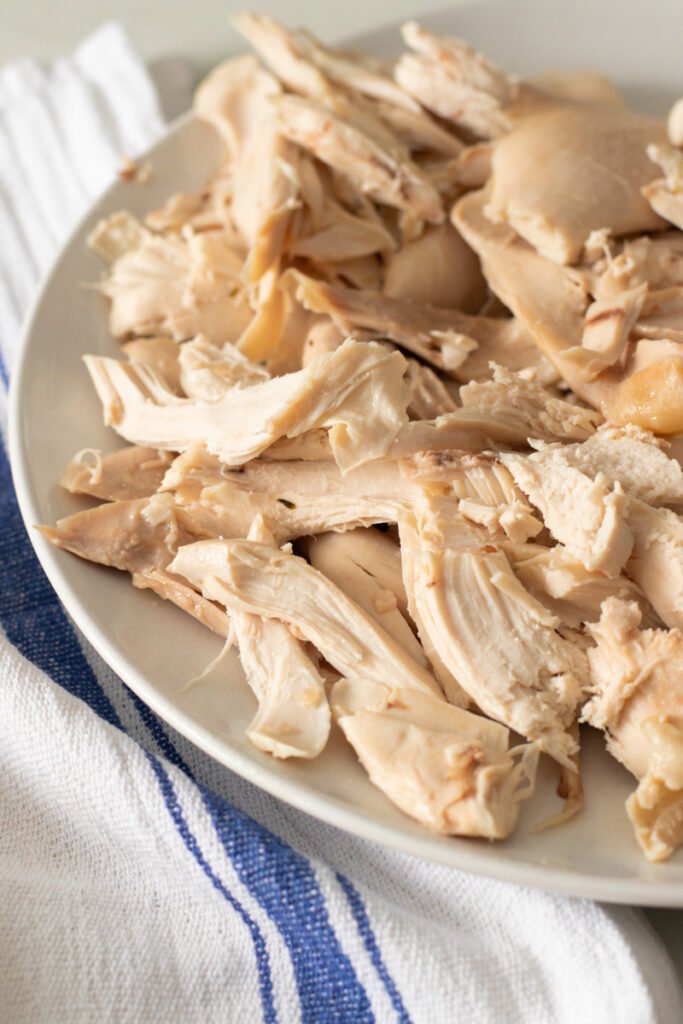 Shredded poached chicken on a plate.