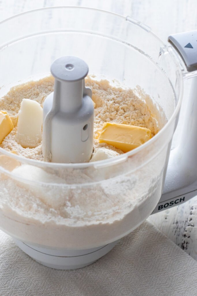 Butter and lard with flour in a mixer.