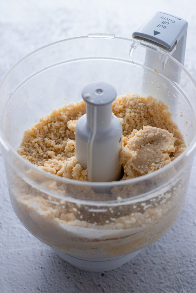 Marzipan in a food processor demonstrating clumping.