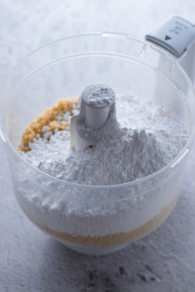 Almonds and powdered sugar in a food processor.