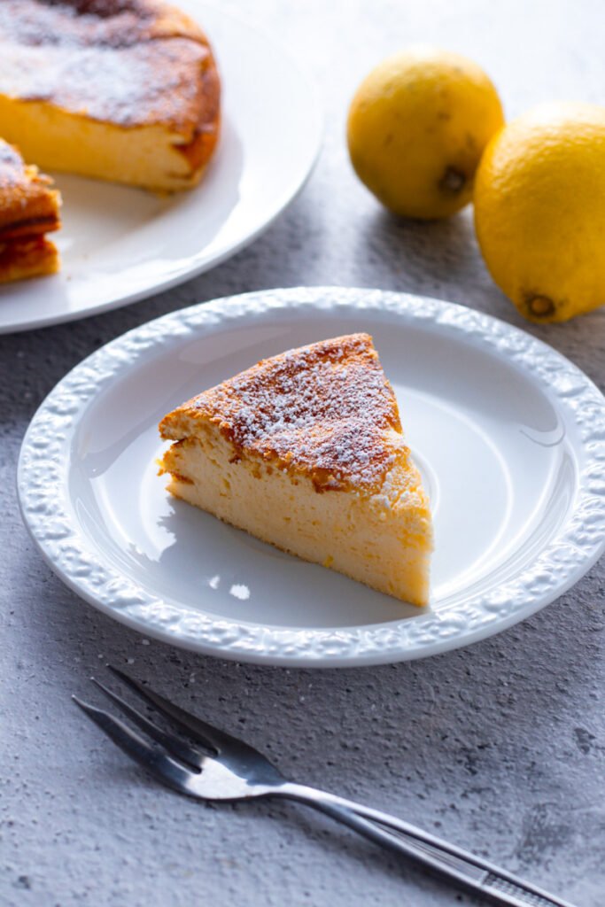 A slice of Lemon Ricotta Cake on a plate.