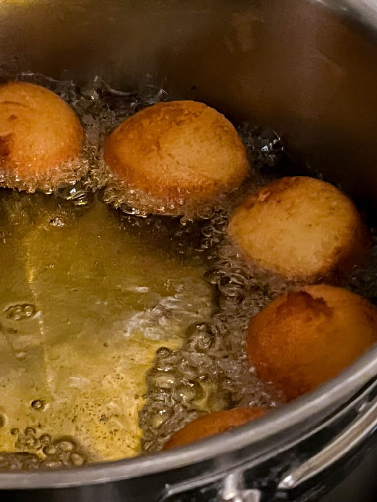 Frying donut holes in hot oil.