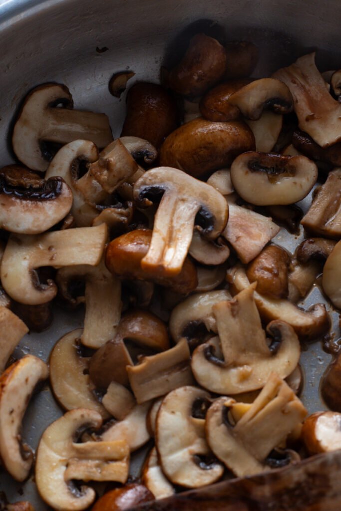 Cooked brown mushrooms on a plate.