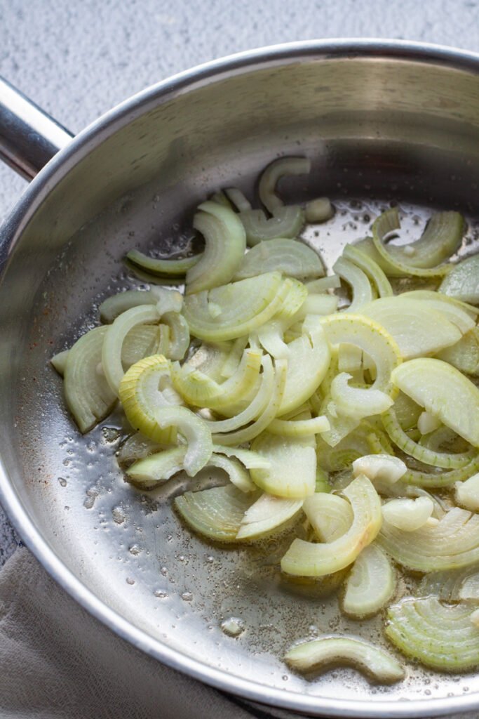 Sliced onions in a saute pan.