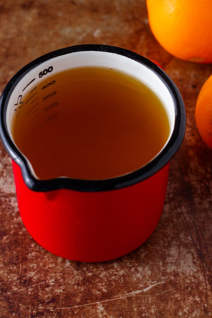 A measuring jug with 500ml of orange liquid inside.