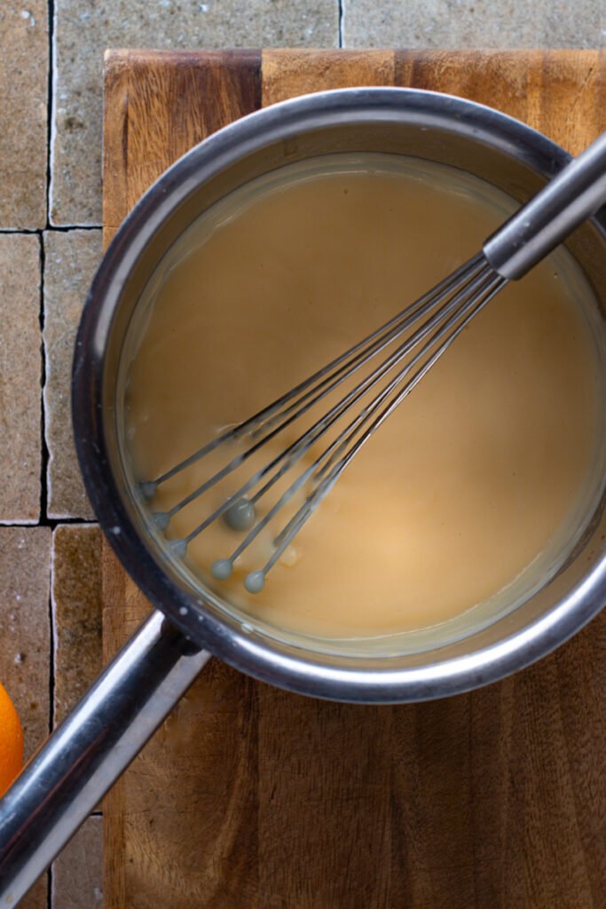 Advocaat pastry cream with a whisk in a saucepan.